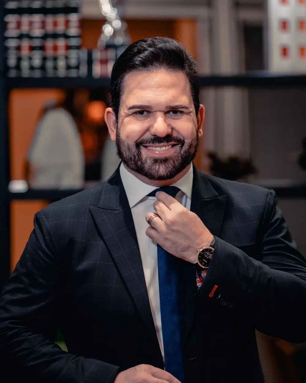 João Vítor Caldas ajustando a gravata no escritório
